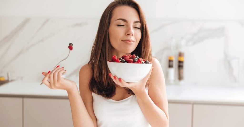 woman eating fresh fruits and vegetables